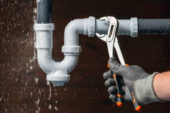 Close-up of a leaking pipe joint being inspected