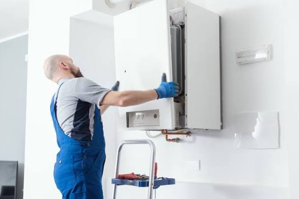 Joel mounting a wall-hung boiler during an installation