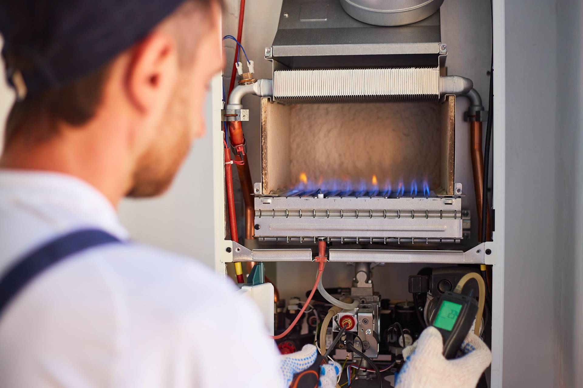 Engineer checking the flame on an open gas boiler